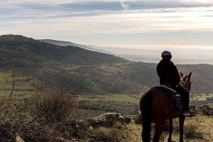 A person riding a horse on a hill overlooking a valley. 3