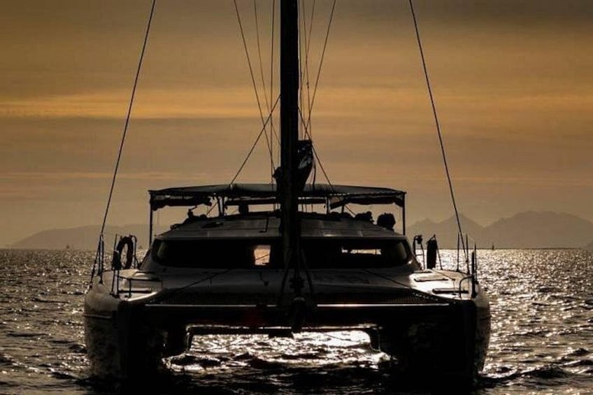A sailboat on the water with a mountainous backdrop during sunset. 3