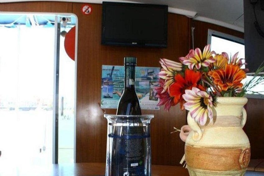 Un intérieur en bois, avec un vase de fleurs, une bouteille et un téléviseur accroché au mur. 4