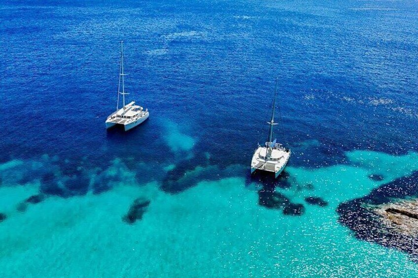 Two sailboats on turquoise waters with clear skies. 4