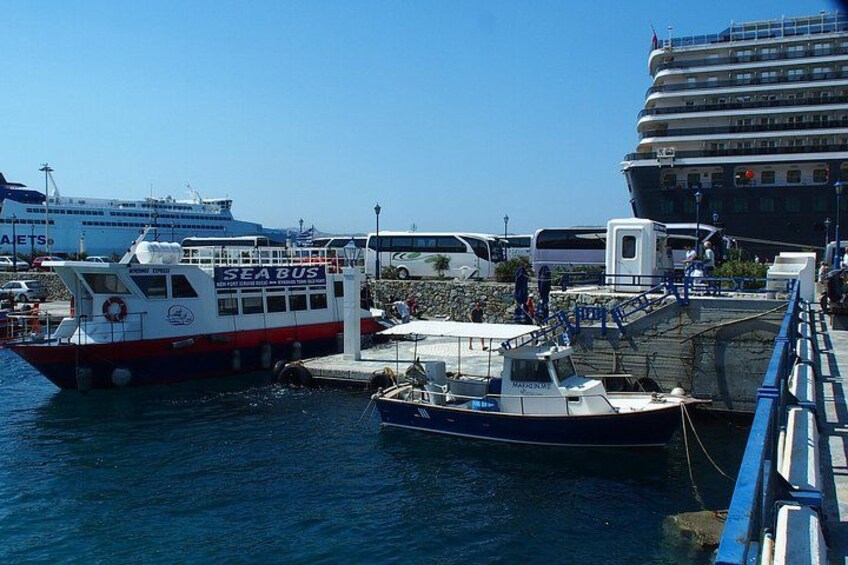 A marina with boats, a ferry, and a cruise ship. 3