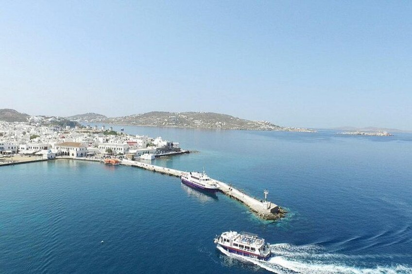 A coastal town with a pier extending into the sea, boats, and a clear sky. 4