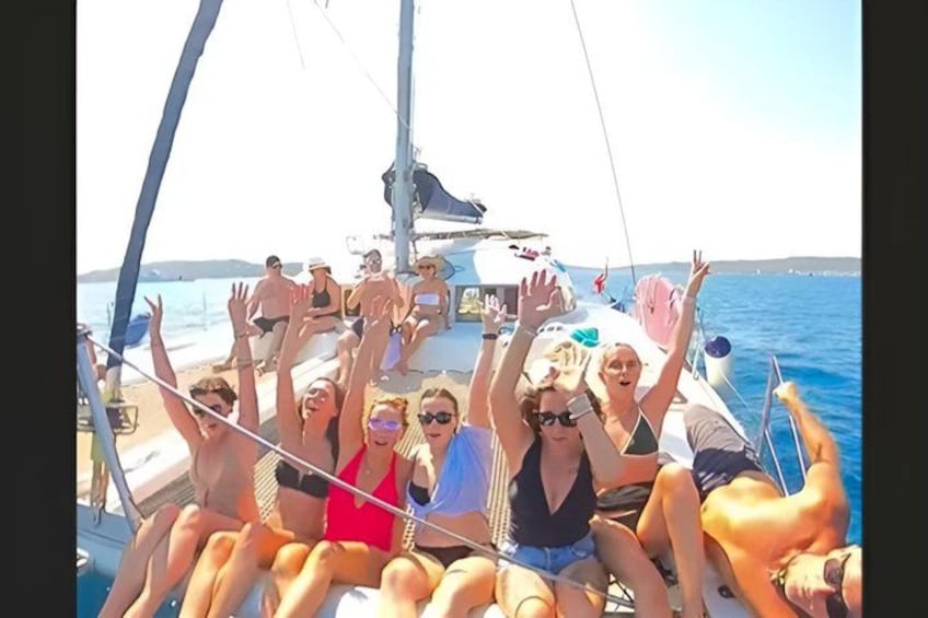 A group of people on a sailboat with the ocean in the background. 4