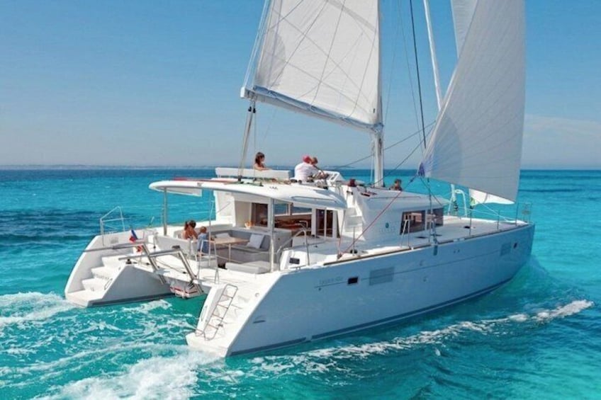 A white catamaran sailing on turquoise waters. 1