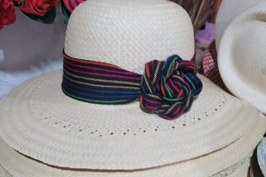 Un sombrero de paja con una cinta tejida de colores y un lazo. 5