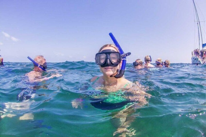 People snorkeling in the ocean with a boat in the background. 4