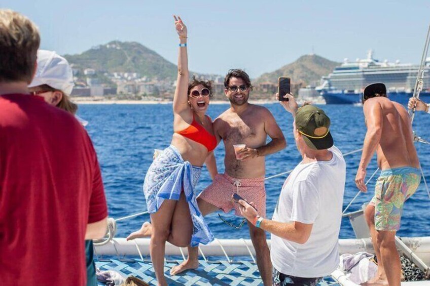 A group of people on a boat with a ship in the background. 3