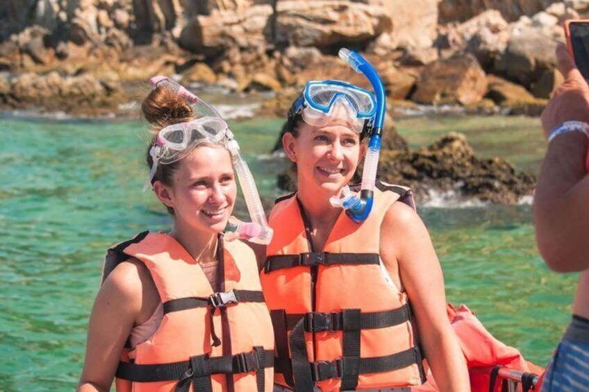 Two people snorkeling with orange life vests and blue snorkels. 5