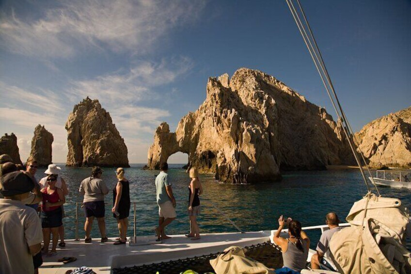 A group of people on a boat near rocky formations in the water. 5