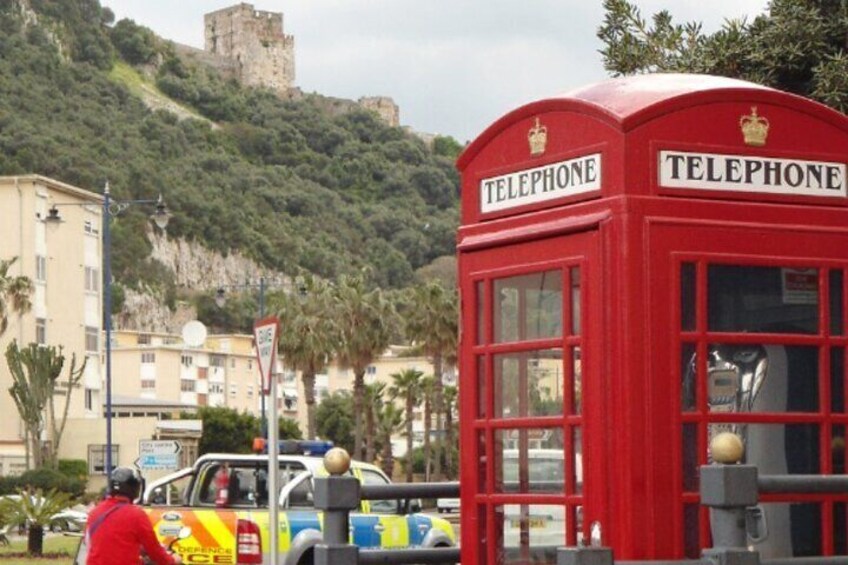 Eine rote Telefonzelle mit einer Burg im Hintergrund. 3