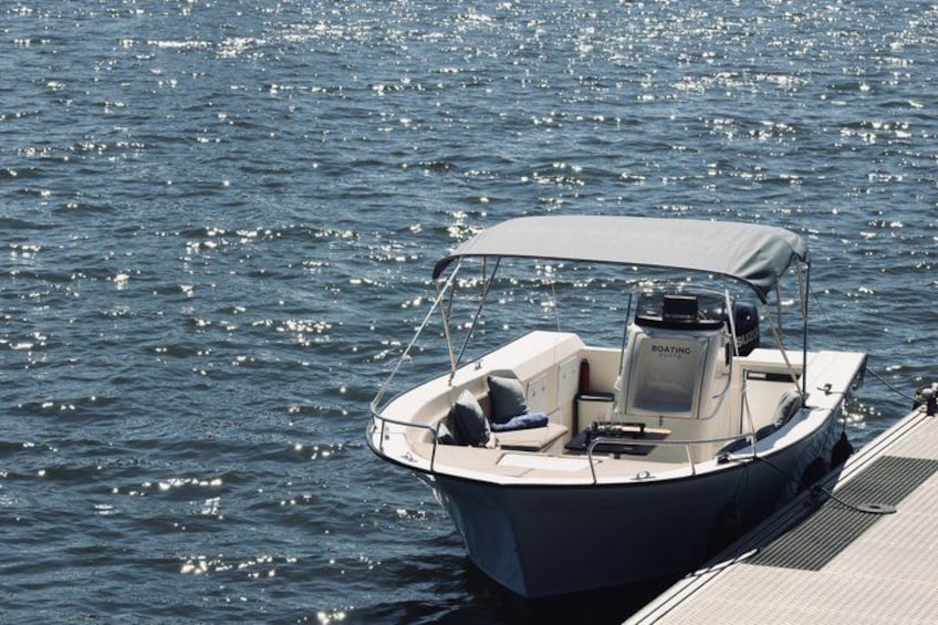 En liten motorbåt låg förtöjd vid en brygga under ett tak. 3