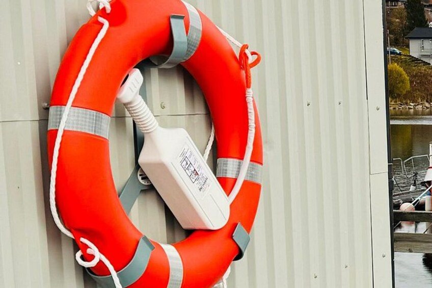 En rød redningskrans fastgjort til et hvidt objekt med en etiket. 3