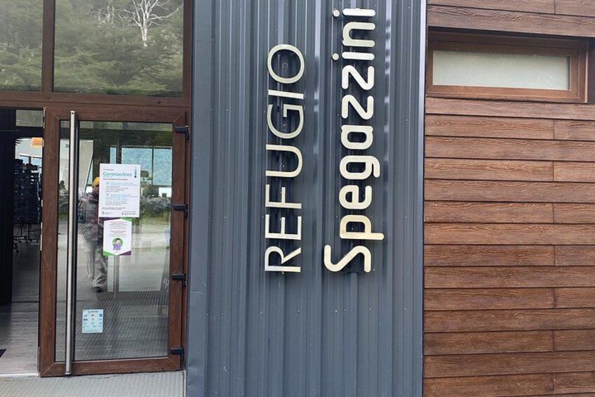 A building entrance with a sign that reads 'REFUGIO Spezzini.' 3