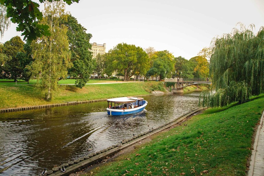 A blue boat on a river with a bridge in the background. 4