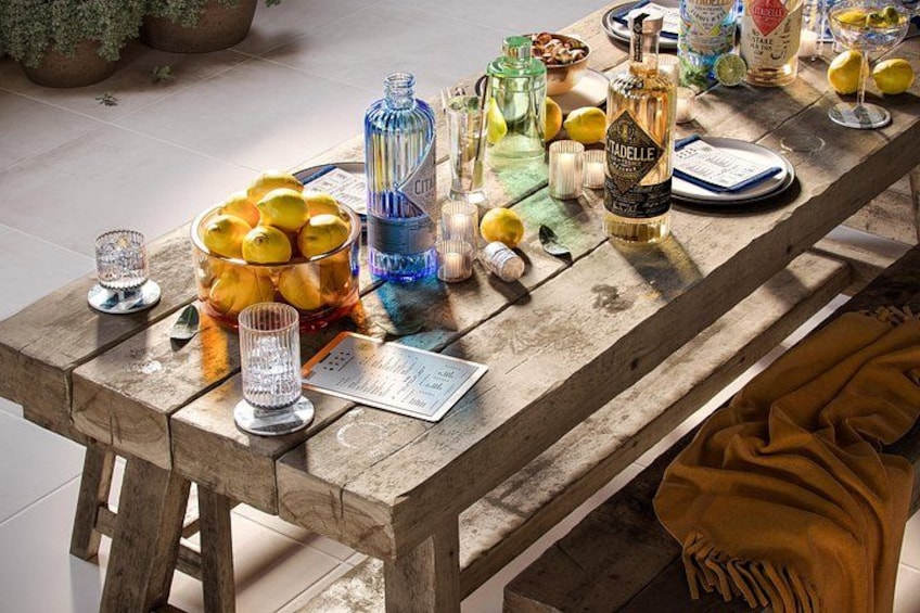 Une table en bois sur laquelle on trouve différentes bouteilles, des verres et un bol de citrons. 3