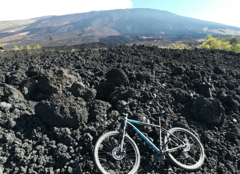 A bicycle on a rocky terrain with a mountain in the background. 3