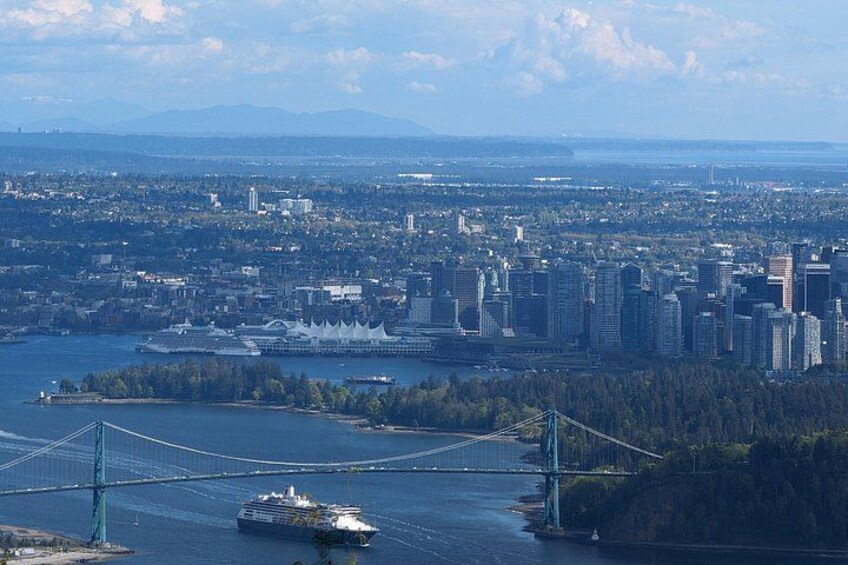 A cityscape with a bridge, a large ship, and a body of water. 1