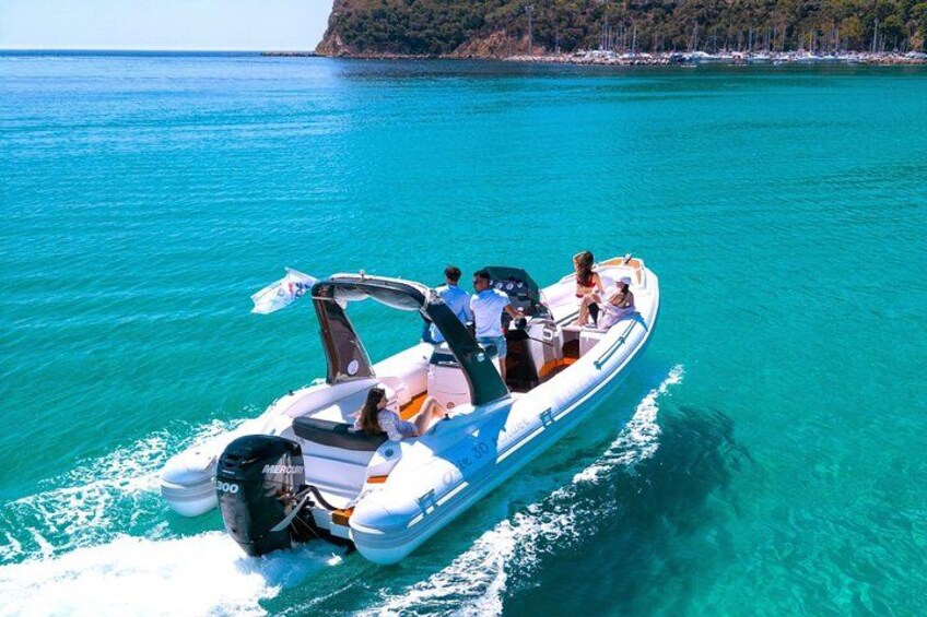 Un bateau à moteur sur une eau turquoise, avec des personnes à bord. 1