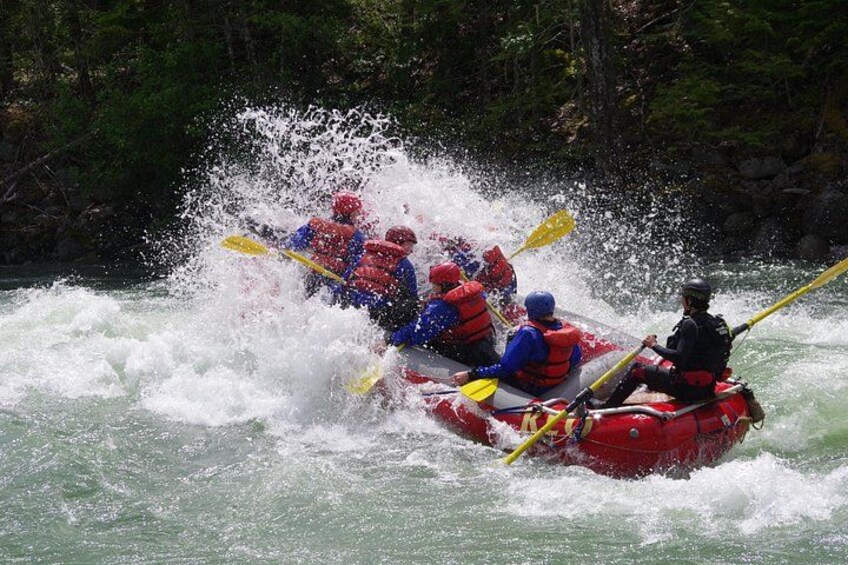 Un groupe de personnes à bord d’un radeau rouge naviguant dans des rapides aux eaux tumultueuses. 4