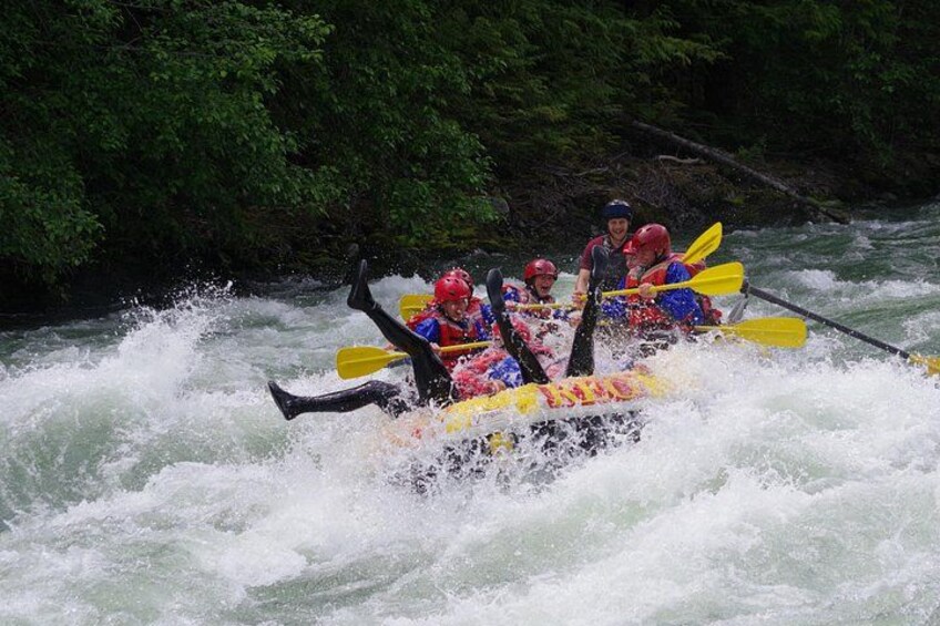 Un groupe de personnes à bord d’un radeau jaune navigue sur une rivière aux eaux tumultueuses et aux rapides. 3