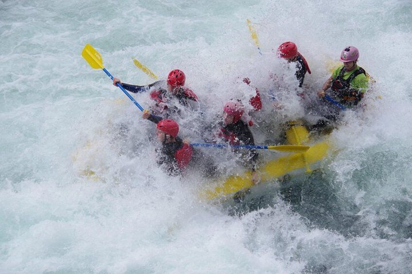 Un groupe de personnes à bord d’un radeau jaune naviguant dans des eaux tumultueuses et agitées. 5