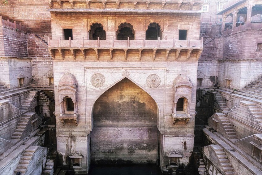 A historic stone archway with intricate carvings and a central passageway. 2