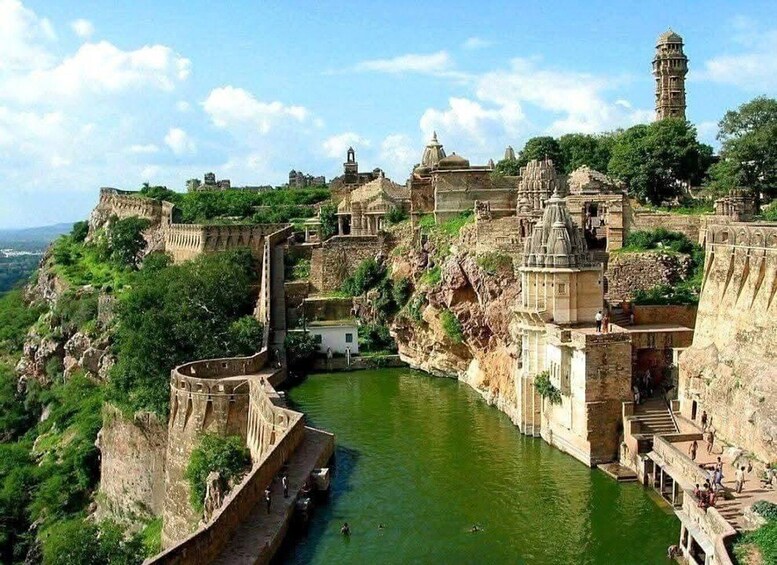 A historic fort with a river running through it, surrounded by lush greenery and ancient architecture. 3