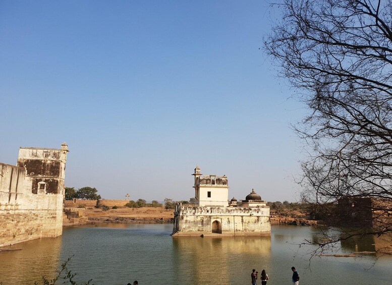 A historic fort with a tower and a bridge over a calm river. 5