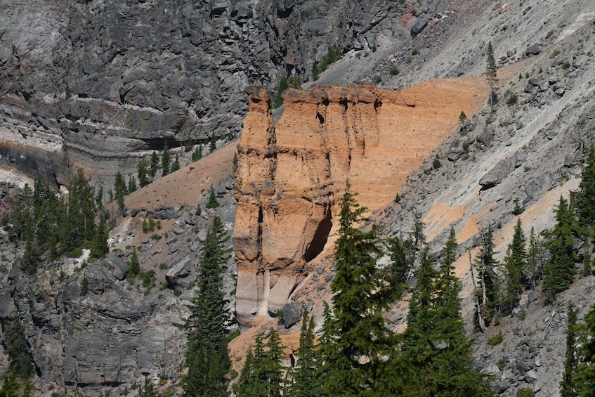 A rugged mountain landscape with a prominent rock face featuring a large vertical crack. 5