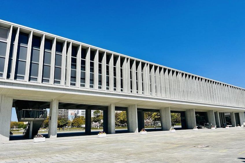 A modern building with a flat roof and a series of columns supporting a horizontal structure. 3