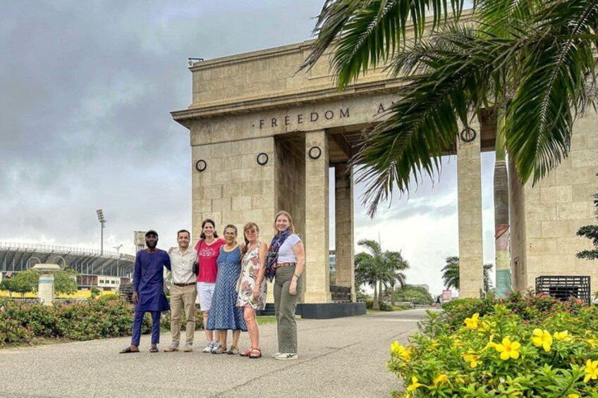 A group of people standing in front of a monument with the inscription 'FREEDOM A'. 5