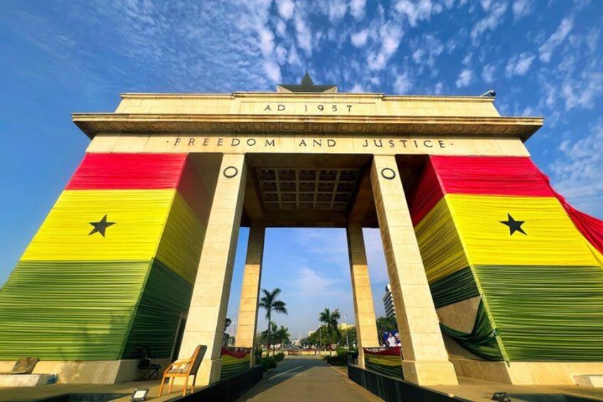 A monument with the inscription 'AD 1957 FREEDOM AND JUSTICE' and the national flag colors. 1