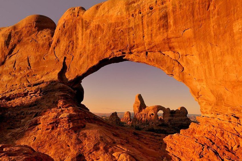 A natural rock arch formation with a clear sky. 1