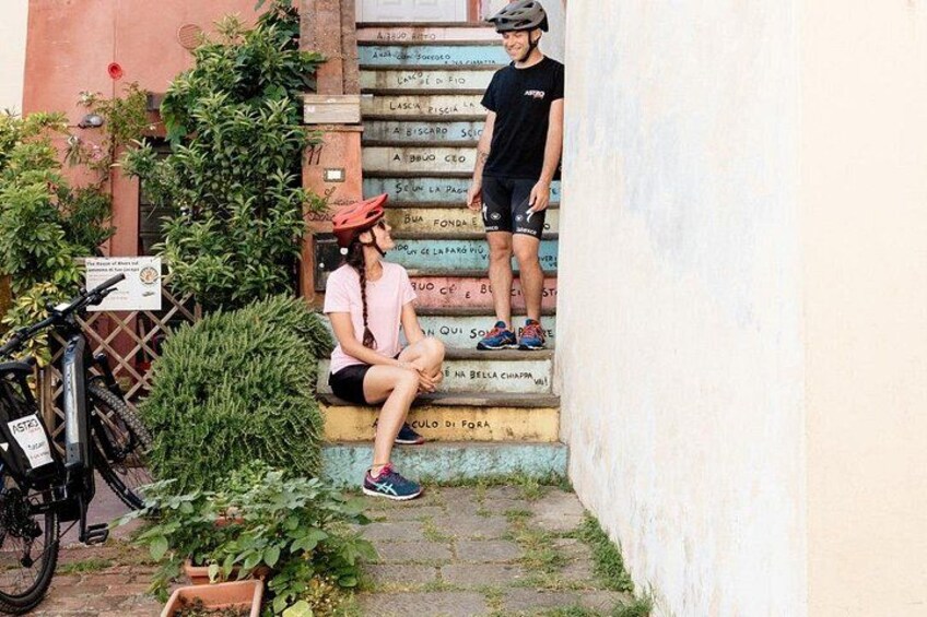 Una persona sentada en unos escalones, una bicicleta y un casco. 3