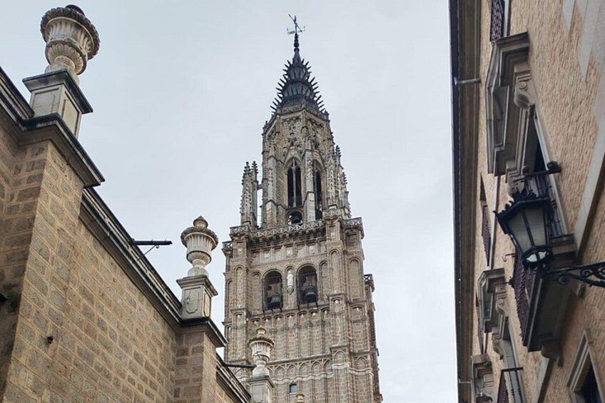 Een toren van een kerk in gotische stijl, met gedetailleerd steenwerk en een spits. 3