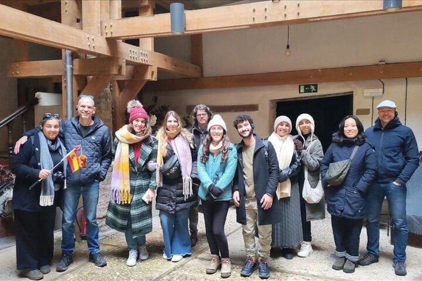 Een groep mensen staat voor een gebouw met houten balken en een bord. 4