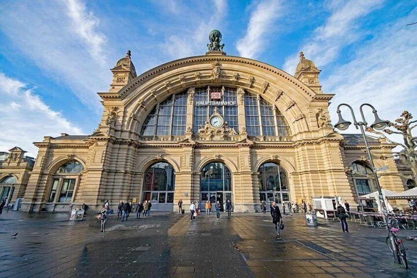 A historic train station with large arched windows and a clock. 5