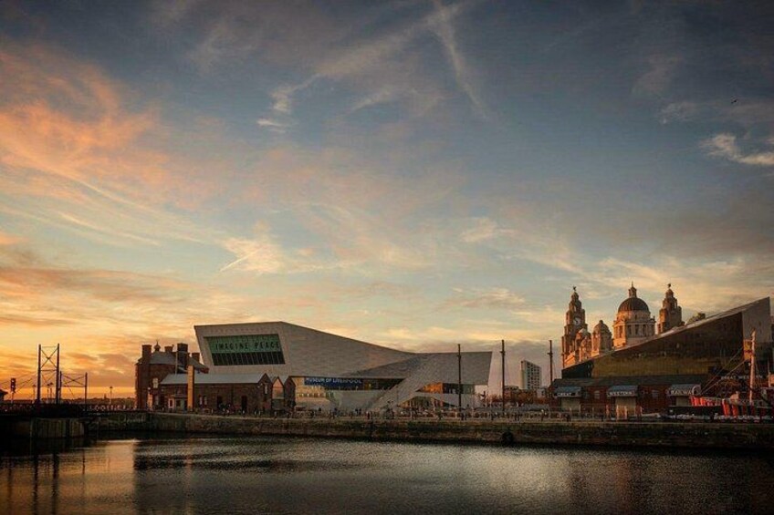 A waterfront cityscape with modern architecture, including a distinctive building with a sloped roof and a classical building with domes. 5
