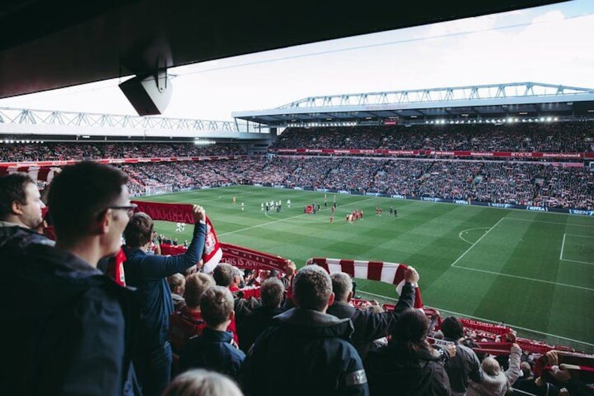 A stadium filled with spectators, a football field, and a large crowd. 1