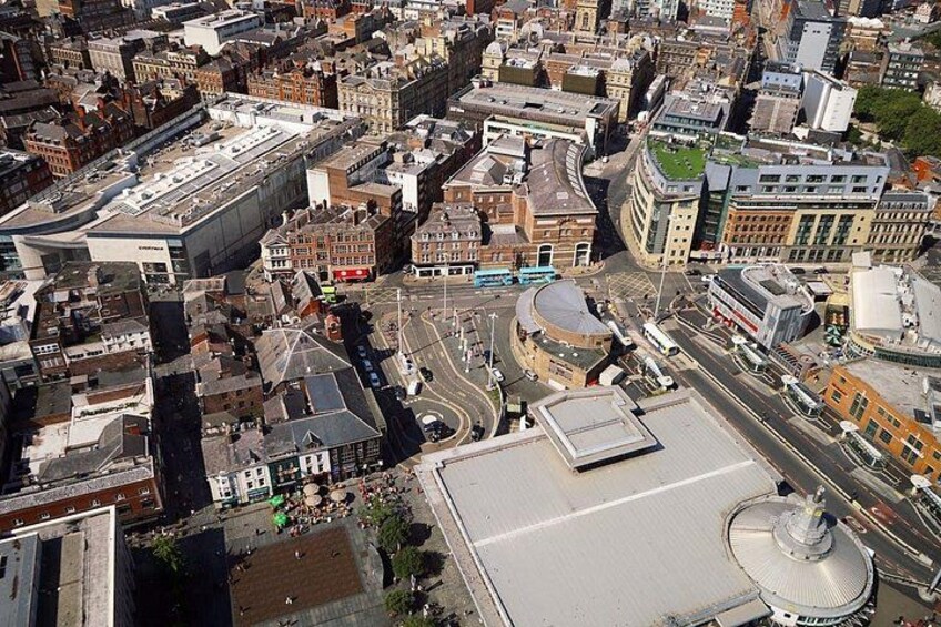 An aerial view of a city with a mix of historical and modern buildings, a prominent dome structure, and a busy intersection. 4