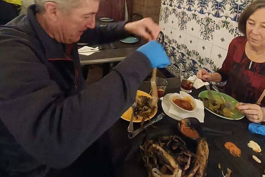 Una persona serve cibo a tavola, con piatti pieni e una bottiglia. 2