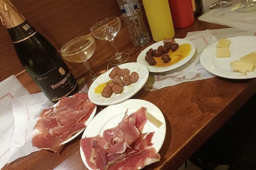 Ein Tisch mit Fleischplatten, einer Weinflasche und Gläsern. 3