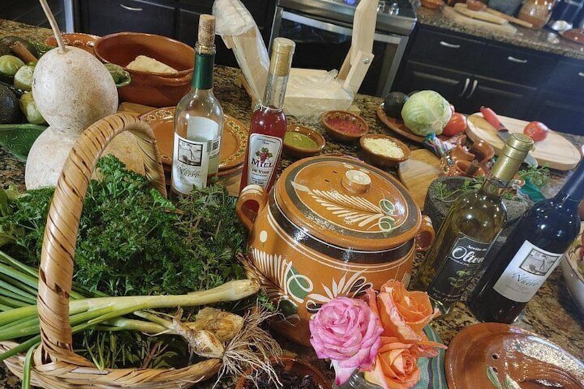 A kitchen counter with various food items, bottles, and a large pot. 1