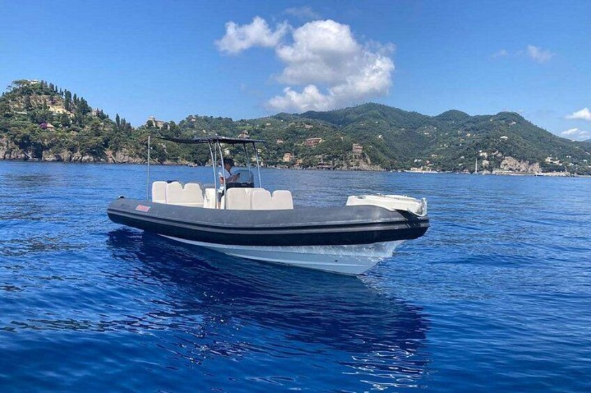 A motorboat on calm water with a mountainous coastline in the background. 2