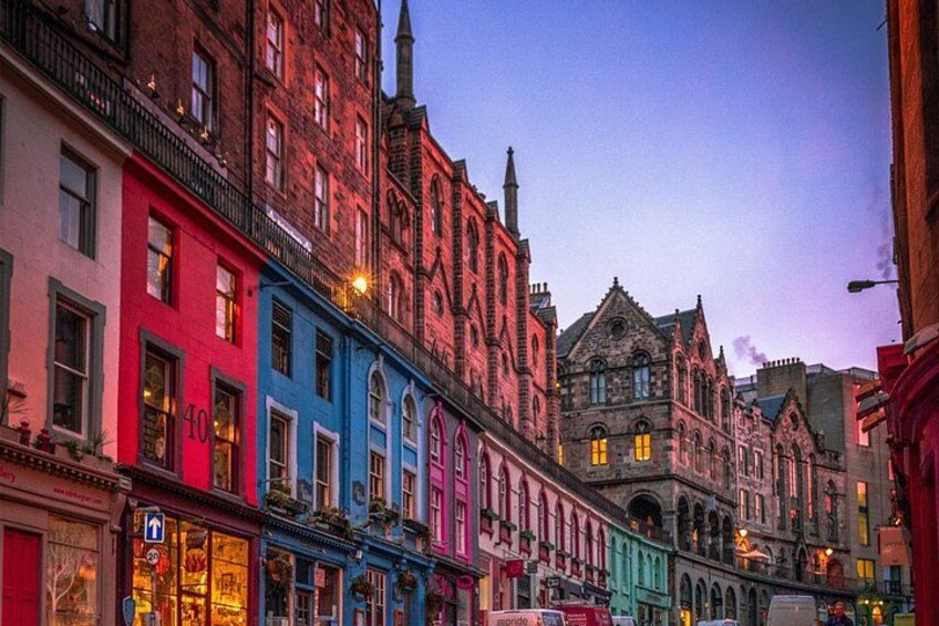 A street with colorful buildings, a large historic building, and a clear sky. 2