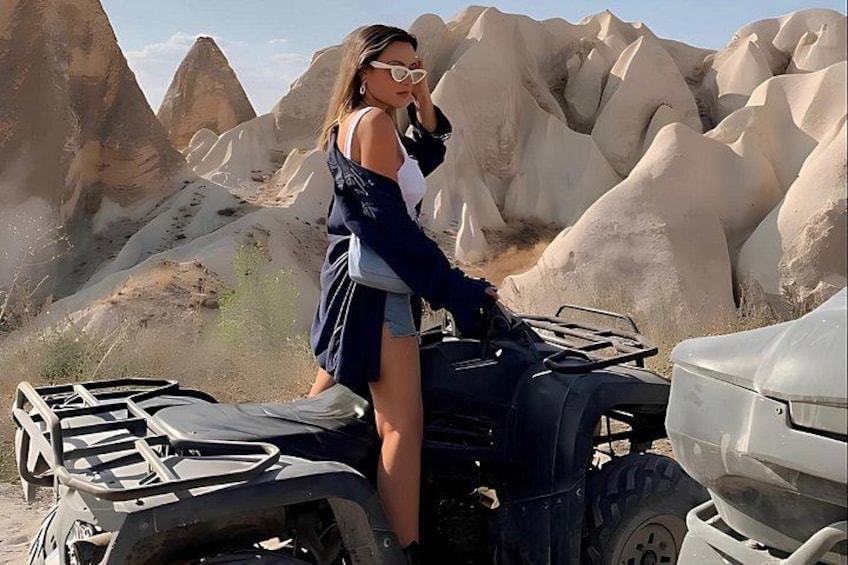 En person kører på en quad bike i et ørkenlandskab med store klippeformationer. 3