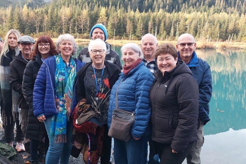 Un grupo de personas junto a un lago tranquilo con un fondo boscoso. 2