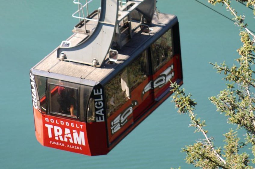 Una funivia con la scritta 'GOLDBELT TRAM' e 'JUNEAU, ALASKA' sospesa sopra l'acqua. 3