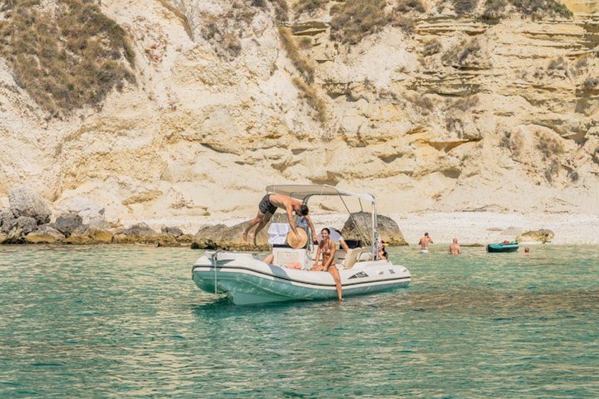 Un gruppo di persone su una piccola barca gonfiabile vicino a una costa rocciosa. 2