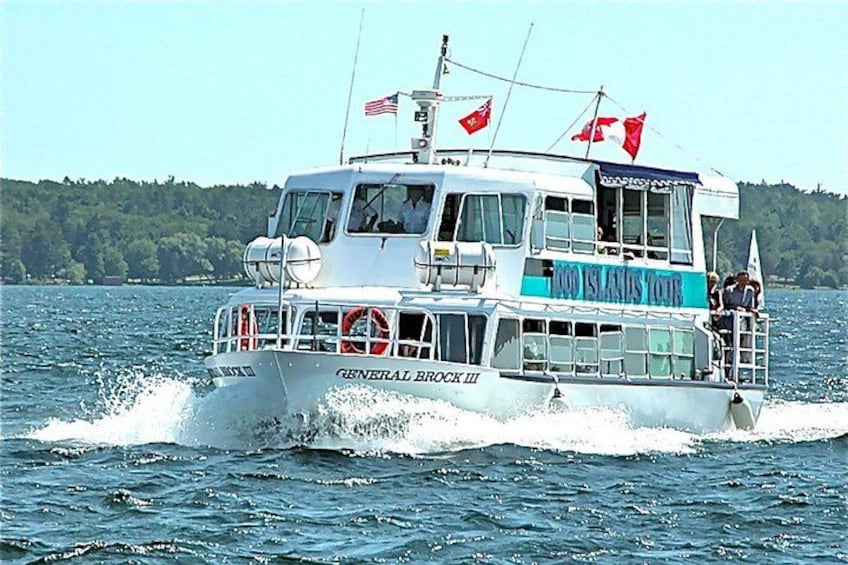 A boat named 'General Brock III' with flags, moving on water. 1